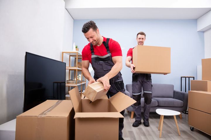 Movers packing boxes in a living room (Packing Services) by Affordable Moving Solutions of Ohio